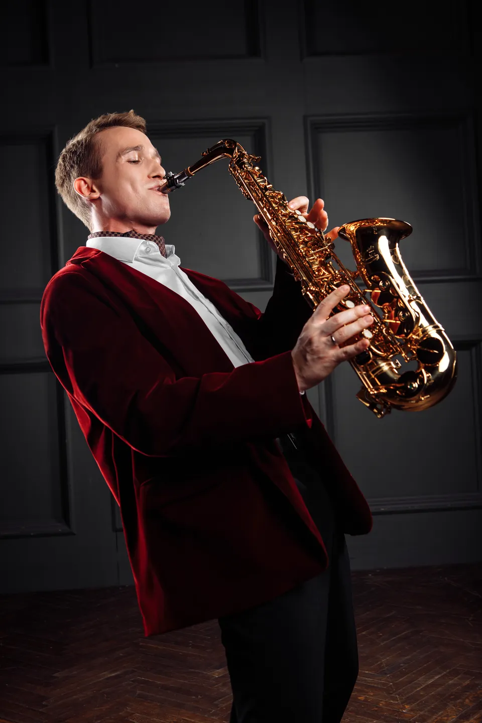 Leo Sax играет на саксофоне в бордовом сценическом образе